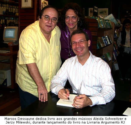 Foto de Marcos Dessaune autografando livro para Aleida Schweitzer e Jerzy Milewski na Livraria Argumento do Leblon